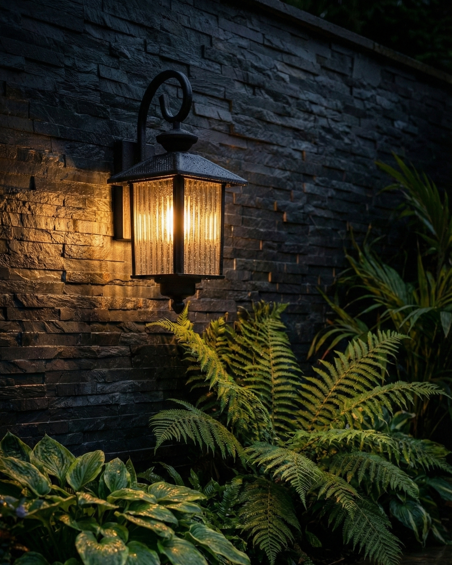 Outdoor light fixture on a stone wall with greenery
