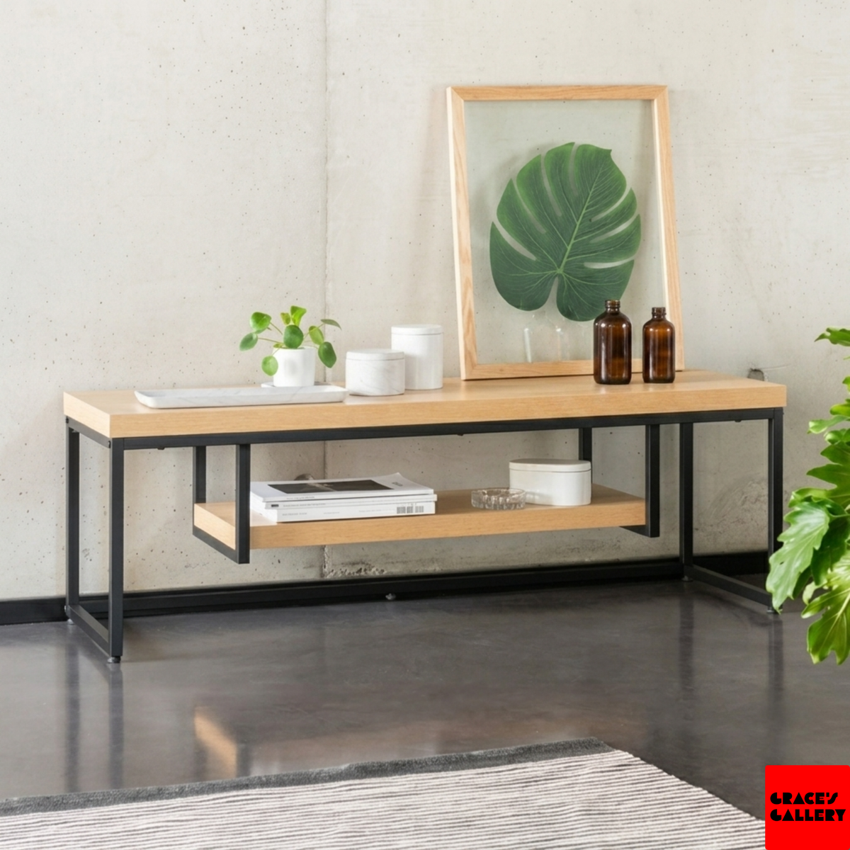 Pine and steel media console styled with a plant, vases and framed leaf print