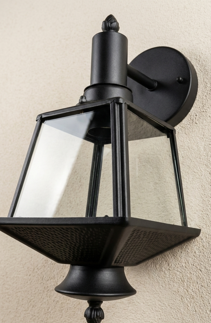 Black outdoor wall light fixture on a beige wall