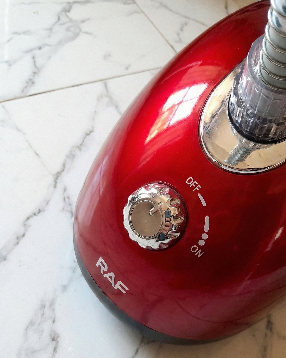 Red handheld vacuum cleaner on a marble floor