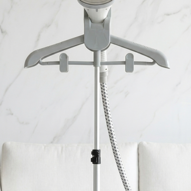 Gray garment steamer with hose and clip on a white background