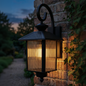 Decorative outdoor wall light fixture on a brick wall at night.