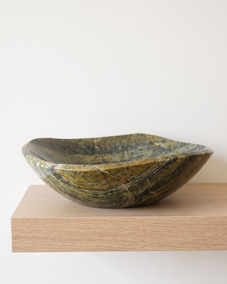Golden Tide serpentine stone serving bowl on a sunlit wooden shelf