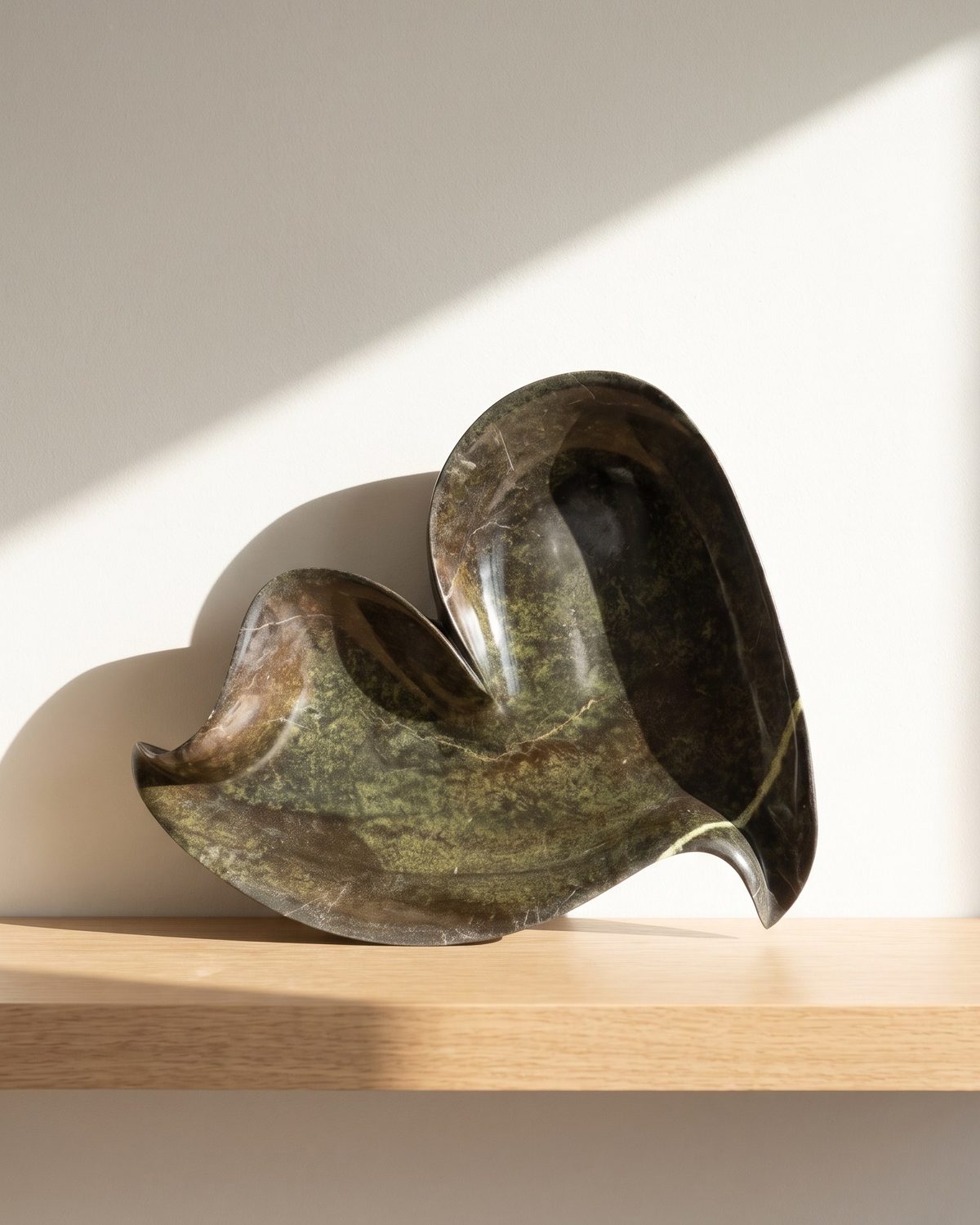 Heart Leaf serpentine stone serving bowl on a sunlit wooden shelf