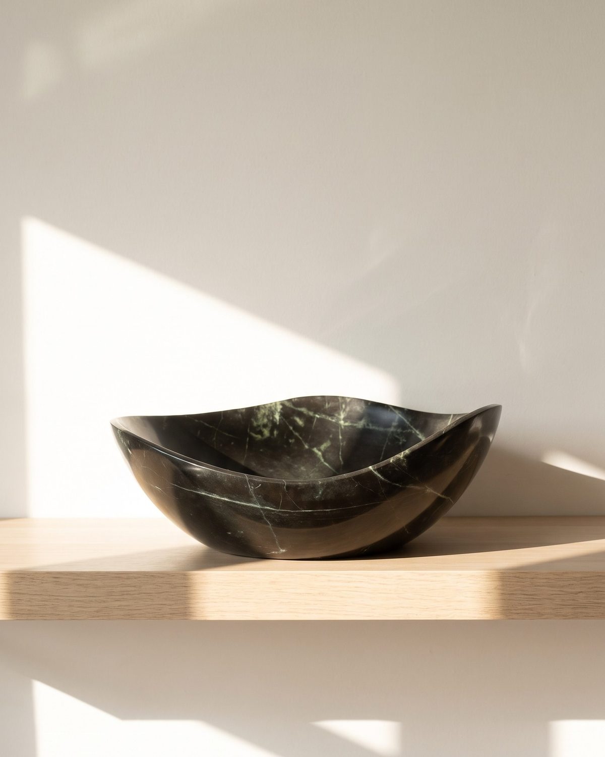Midnight Wave serpentine stone serving bowl on a sunlit wooden shelf